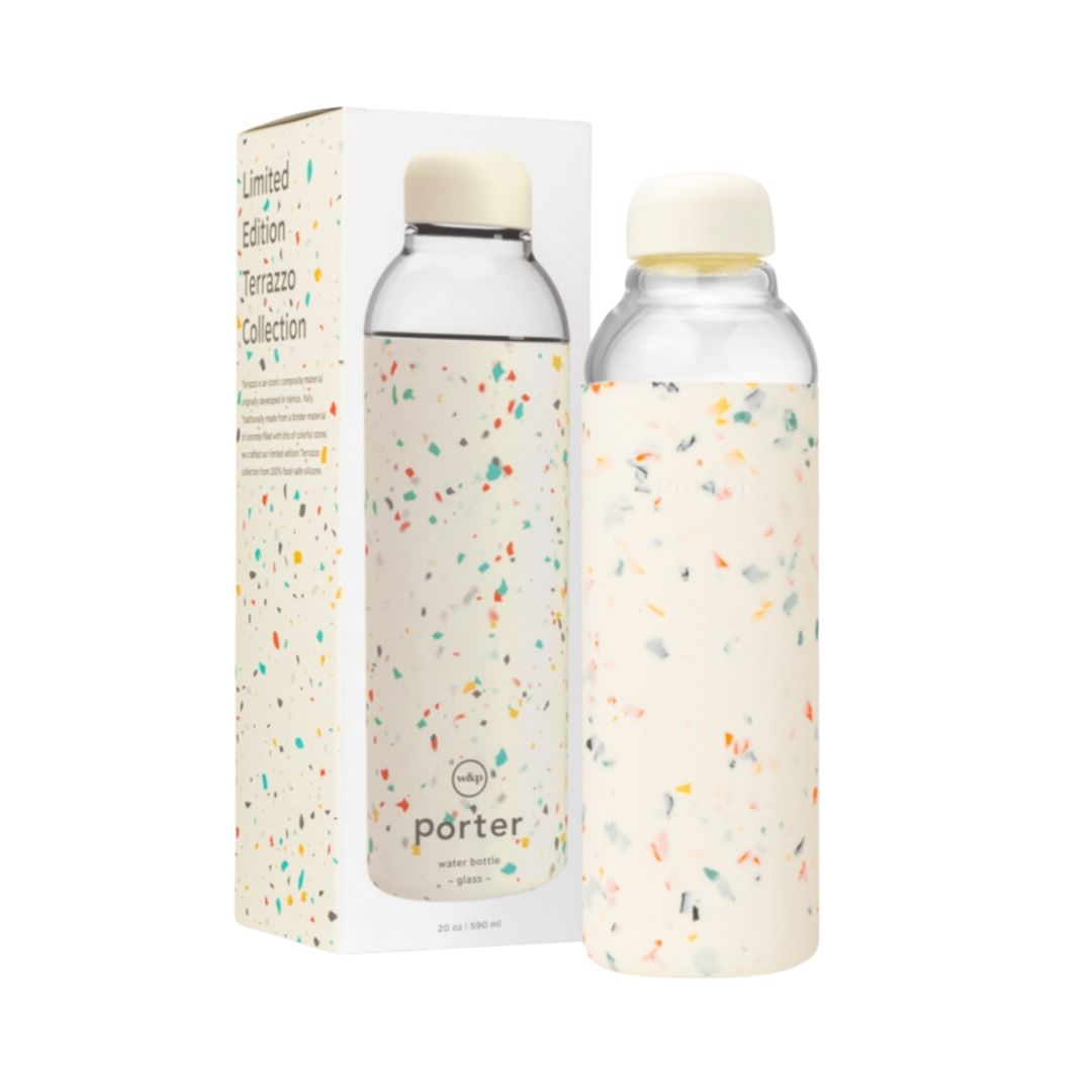 A 20 ounce cream terrazzo silicone-wrapped glass water bottle sits next to its box, showcasing its elegant design and durable construction.