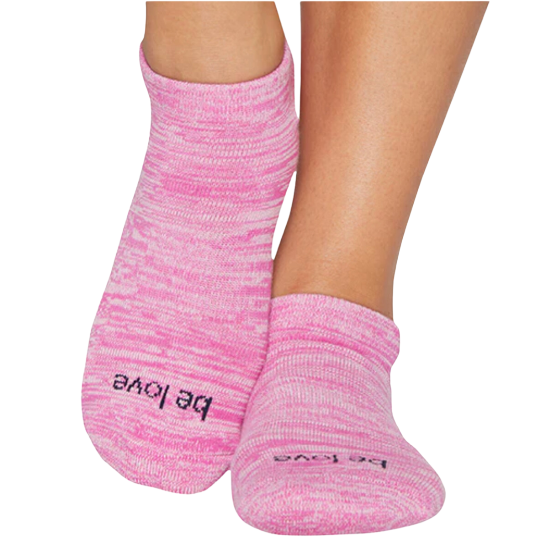 Pink grip sock with "Be Love" on the bottom by Sticky Be, promoting comfort and stability during workouts.
