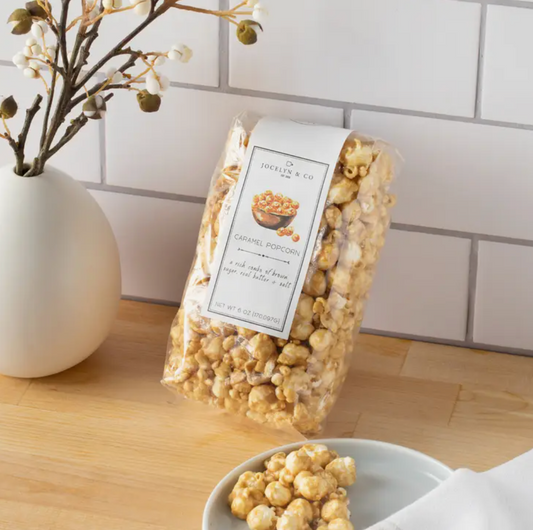 Indulge in the crunchy goodness of this 6oz bag of Vanilla Caramel Popcorn. The packaging displays a close-up image of popcorn kernels generously coated in a smooth vanilla and caramel blend, creating a deliciously sweet and savory snack experience.