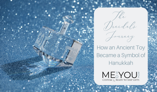 A clear crystal dreidel laying on a sparkling blue back drop at the top of a Me To You Box blog on the history of dreidel's and their meaning.