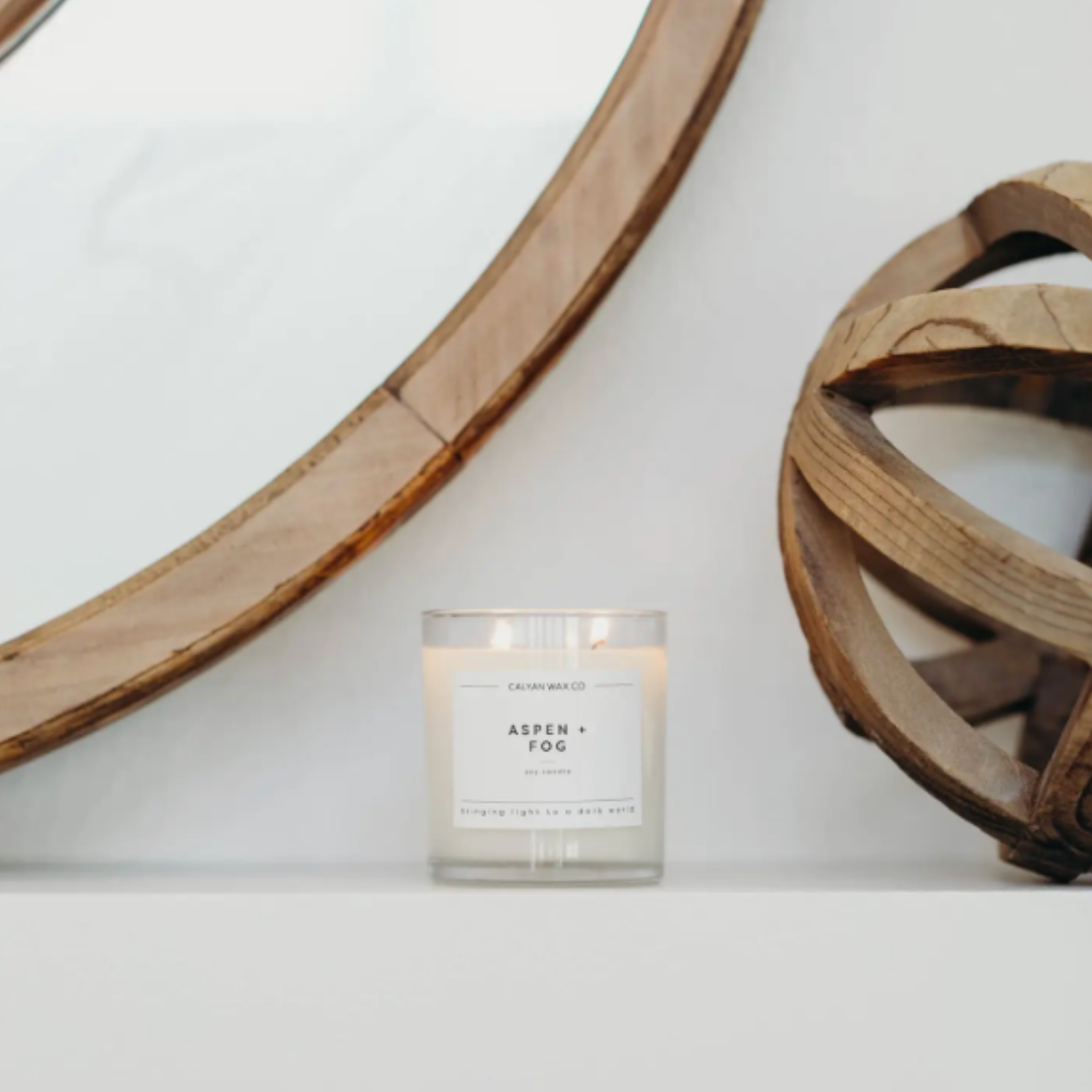 12.5-ounce soy wax candle named 'Aspen and Fog,' with a label that evokes the fresh, crisp scent of aspen trees and misty fog, designed to create a relaxing ambiance.