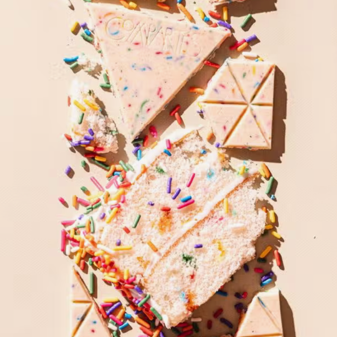 Decadent white chocolate bar by Compartes, featuring a cake-filled center and delightful sprinkles.