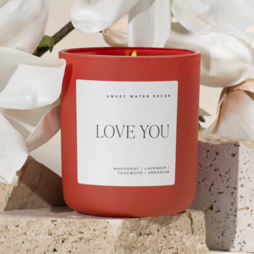 15oz red candle with a wood lid, offering a warm blend of Driftwood, Mahogany, and floral notes of lavender and geranium, perfect for creating a romantic ambiance.