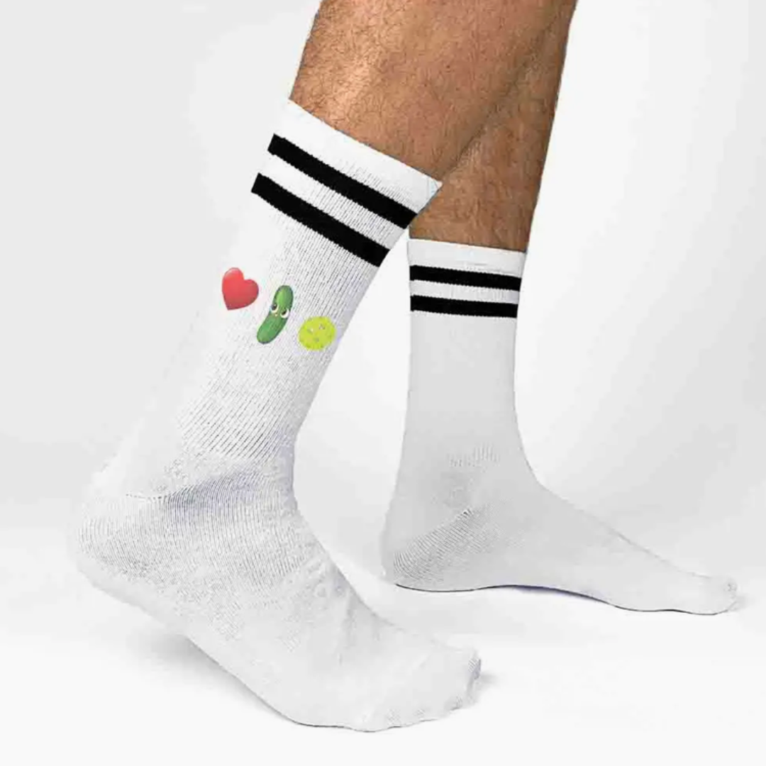 Vibrant women's crew pickleball socks with heart, pickle, and pickleball illustrations, demonstrating passion for the game.