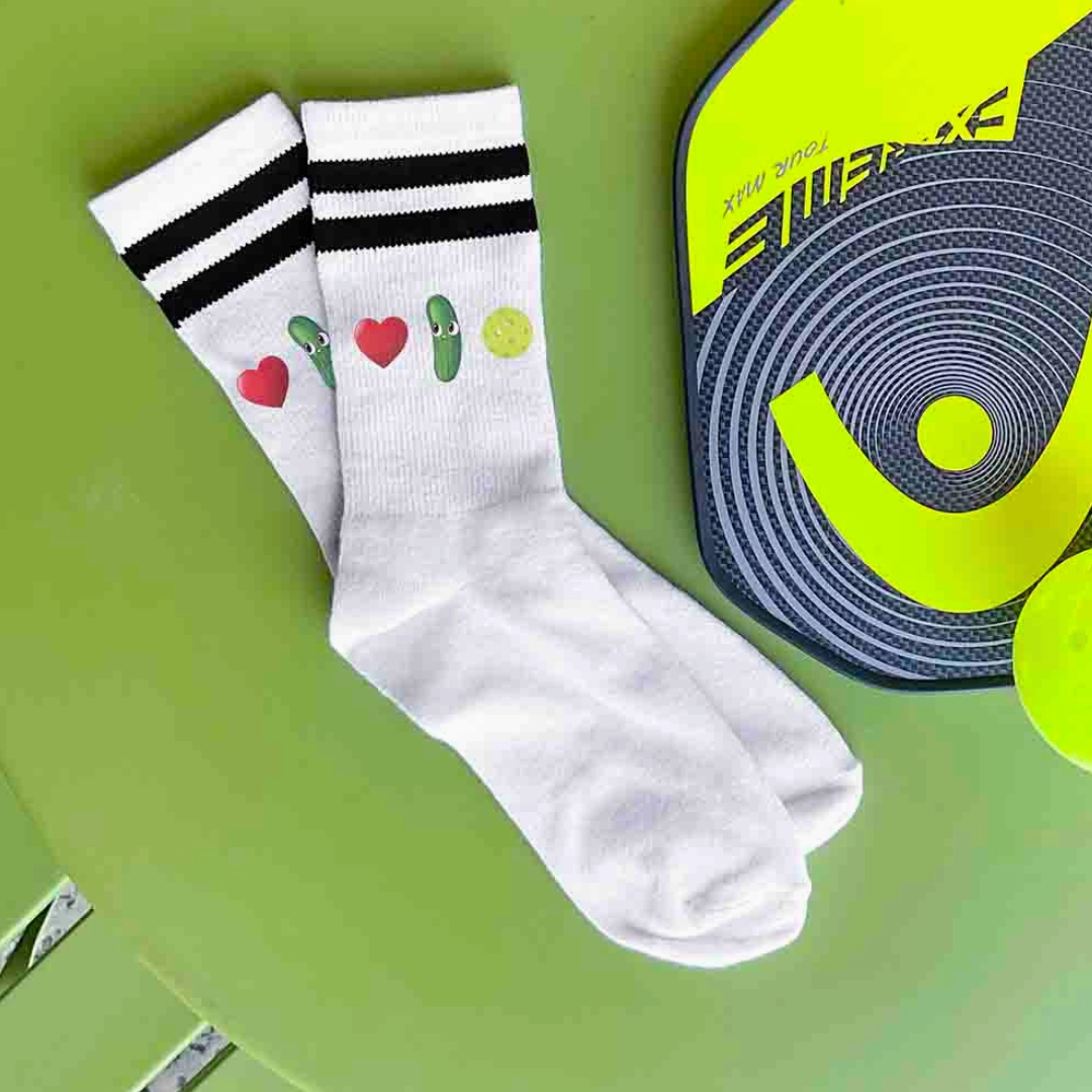 Women's crew pickleball socks featuring heart, pickle, and pickleball graphics, expressing fondness for pickleball.