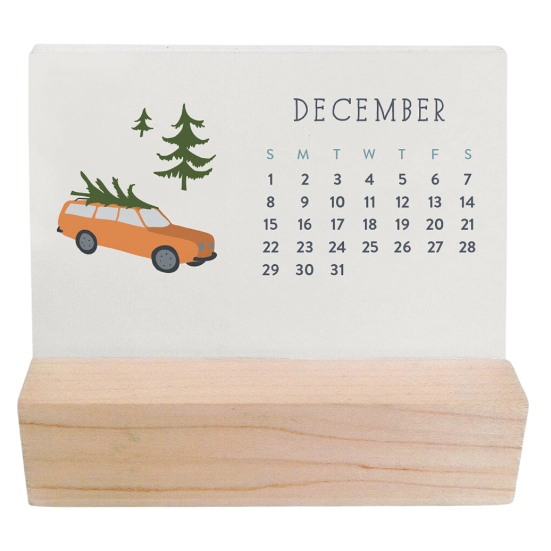 Charming winter village scenes on mini desk calendar with rustic wood base.