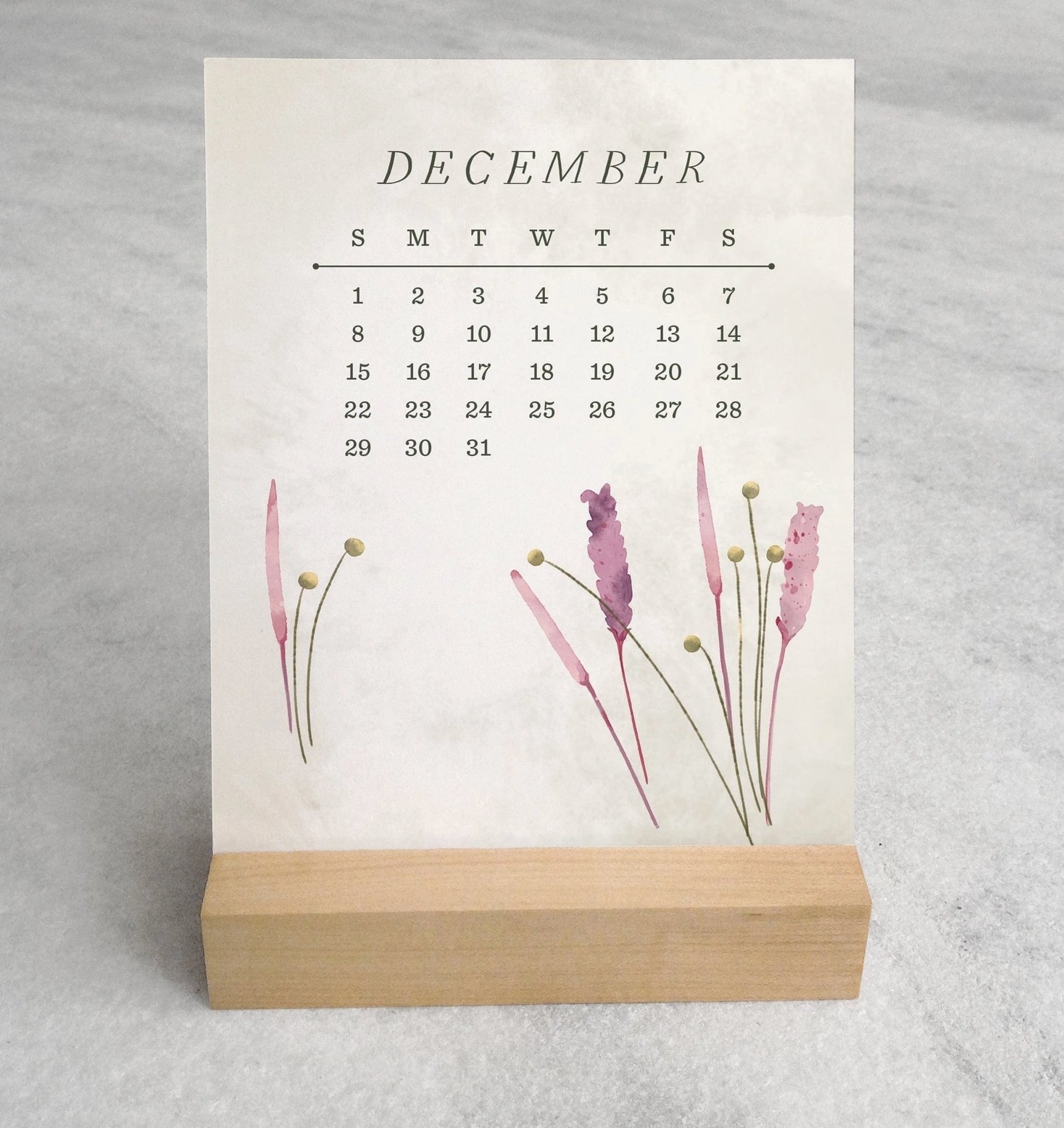 The 2025 Desk Calendar from Me To You Box, featuring 4.25" x 5.5" cards with unique monthly designs and a durable maple wood stand. This compact calendar fits perfectly on any desk, offering daily inspiration and organization with a touch of aesthetic charm.