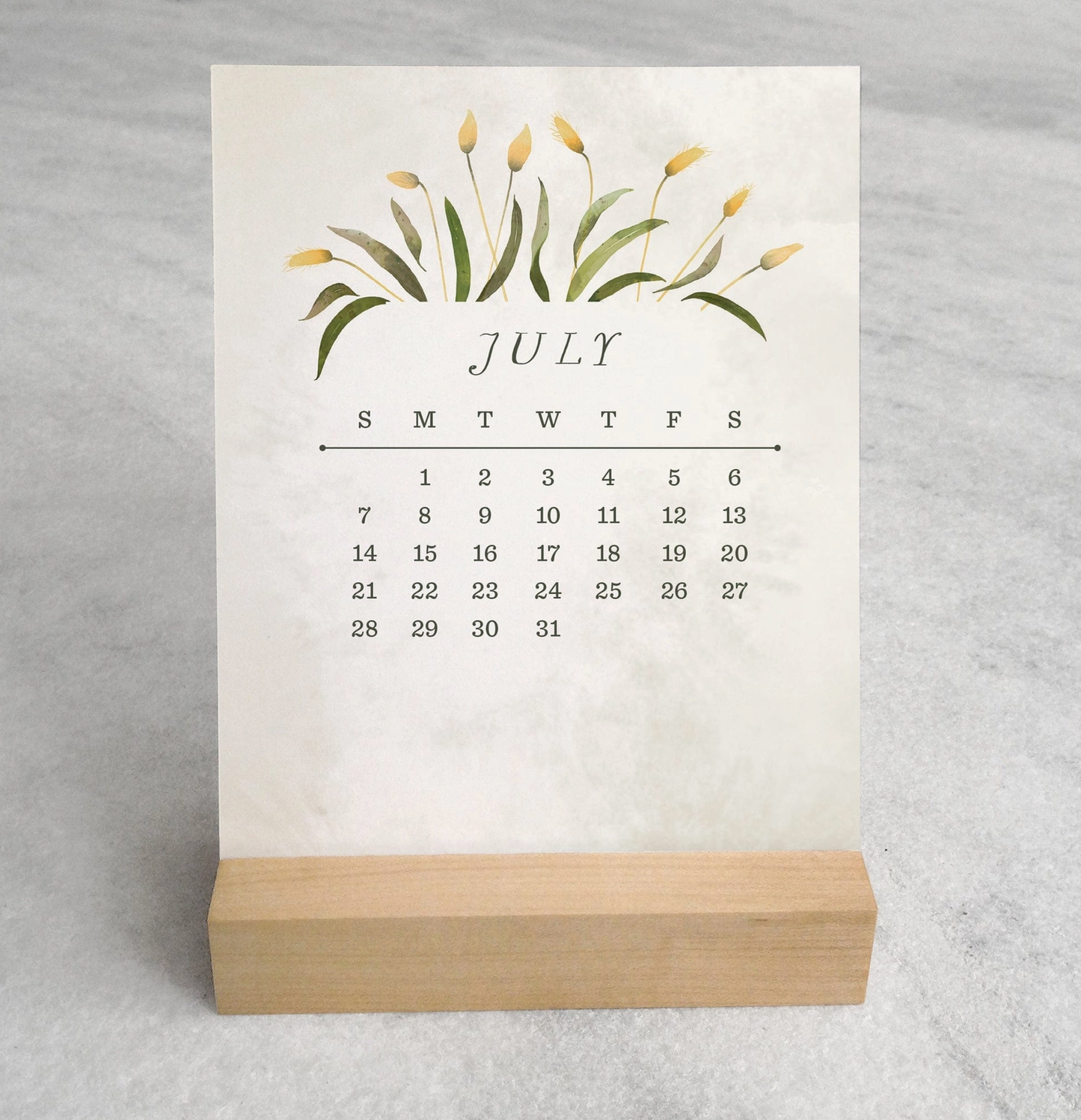 The 2025 Desk Calendar from Me To You Box, featuring 4.25" x 5.5" cards with unique monthly designs and a durable maple wood stand. This compact calendar fits perfectly on any desk, offering daily inspiration and organization with a touch of aesthetic charm.