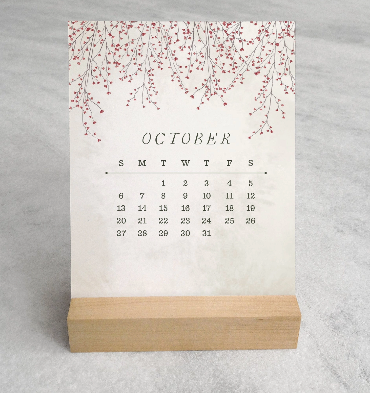 The 2025 Desk Calendar from Me To You Box, featuring 4.25" x 5.5" cards with unique monthly designs and a durable maple wood stand. This compact calendar fits perfectly on any desk, offering daily inspiration and organization with a touch of aesthetic charm.