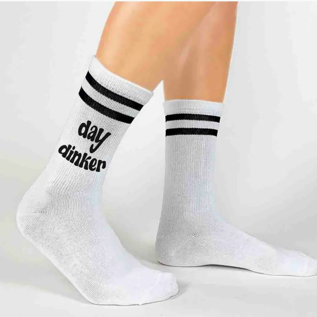 Vibrant women's crew pickleball socks adorned with the words 'Day Dinker', perfect for expressing pickleball enthusiasm.