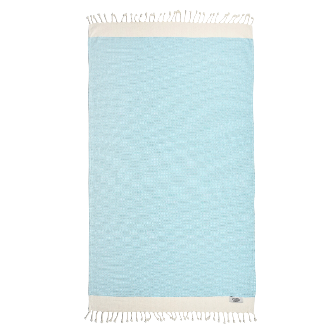 A luxurious ocean blue and cream-colored peshtemal Turkish beach towel, elegantly designed with soft, textured fabric and traditional motifs, ideal for lounging by the ocean or poolside.