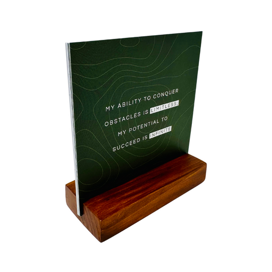 A set of beautifully designed positive affirmation cards displayed on a wooden stand.