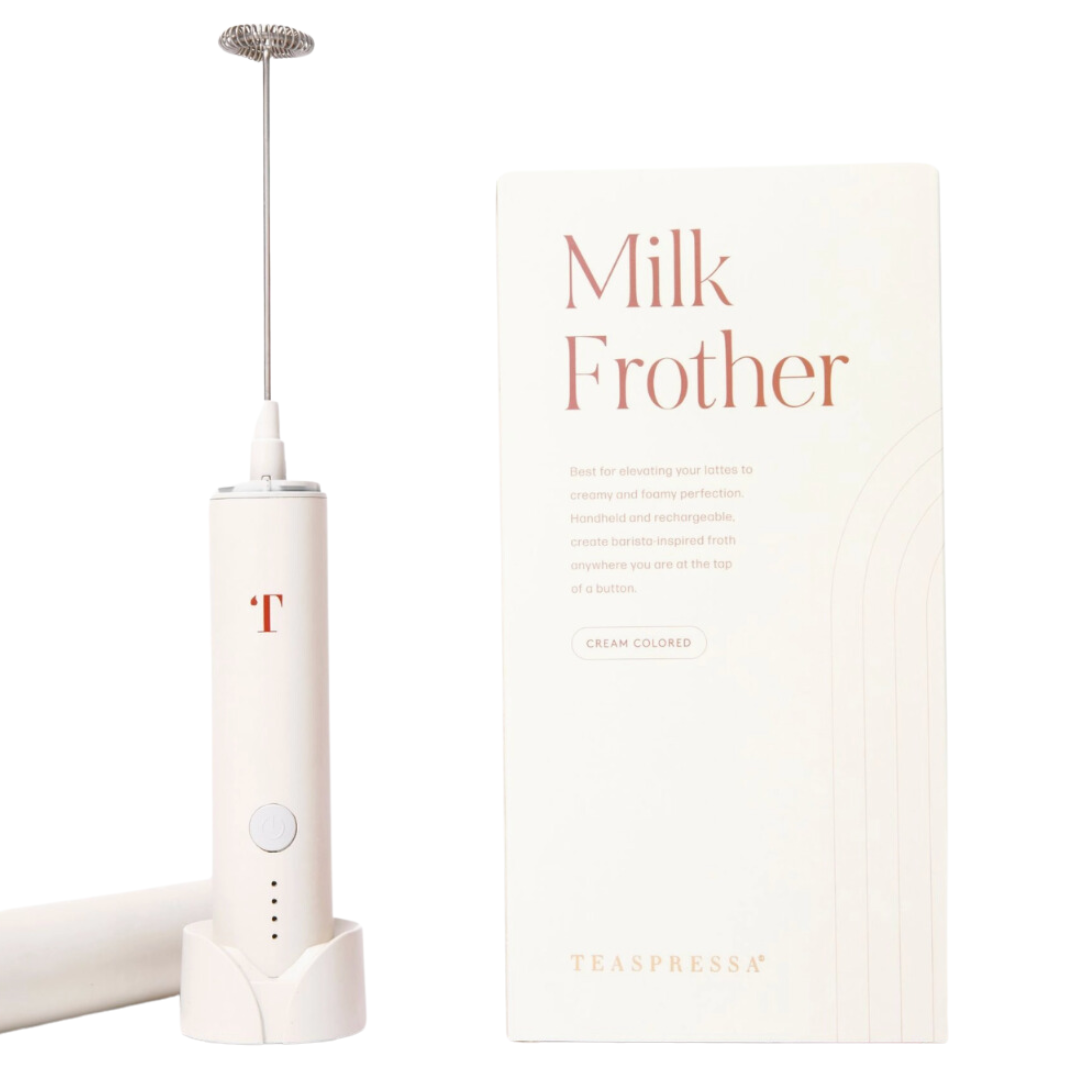 A cream-colored milk frother, featuring a sleek design with a frothing wand and ergonomic handle, ideal for creating frothy milk for coffee drinks.
