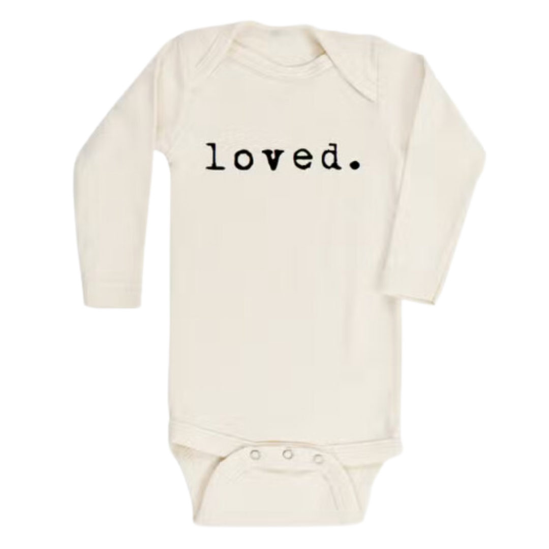 Organic cotton baby bodysuit in natural cream with 'loved.' text in black.
