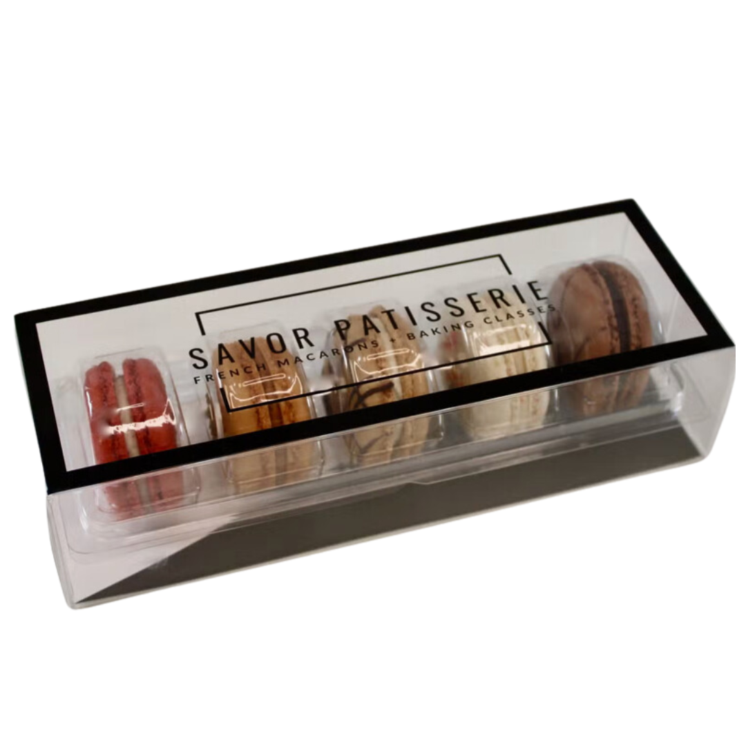 Assorted Savor Patisserie French macarons in vibrant hues, neatly arranged in a box.