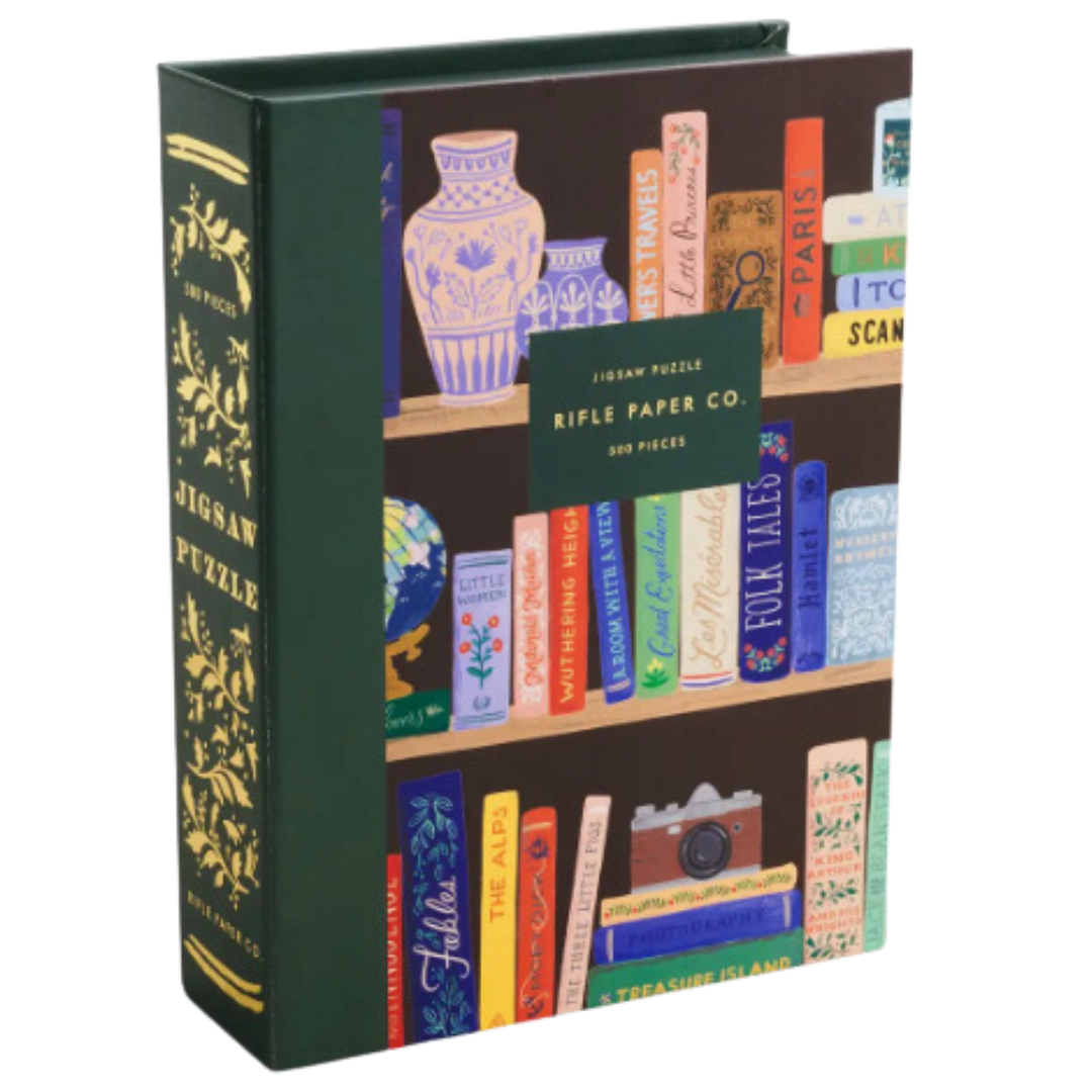 500-piece Bookshelf jigsaw puzzle from Rifle Paper Co., illustrated with vibrant details and packaged in an elegant box with gold foil accents and magnetic closure.