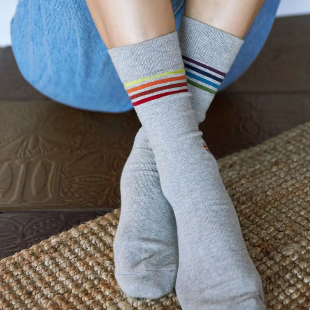 Grey socks with a burst of color: Rainbow-striped Pride crew socks for a fashionable statement.