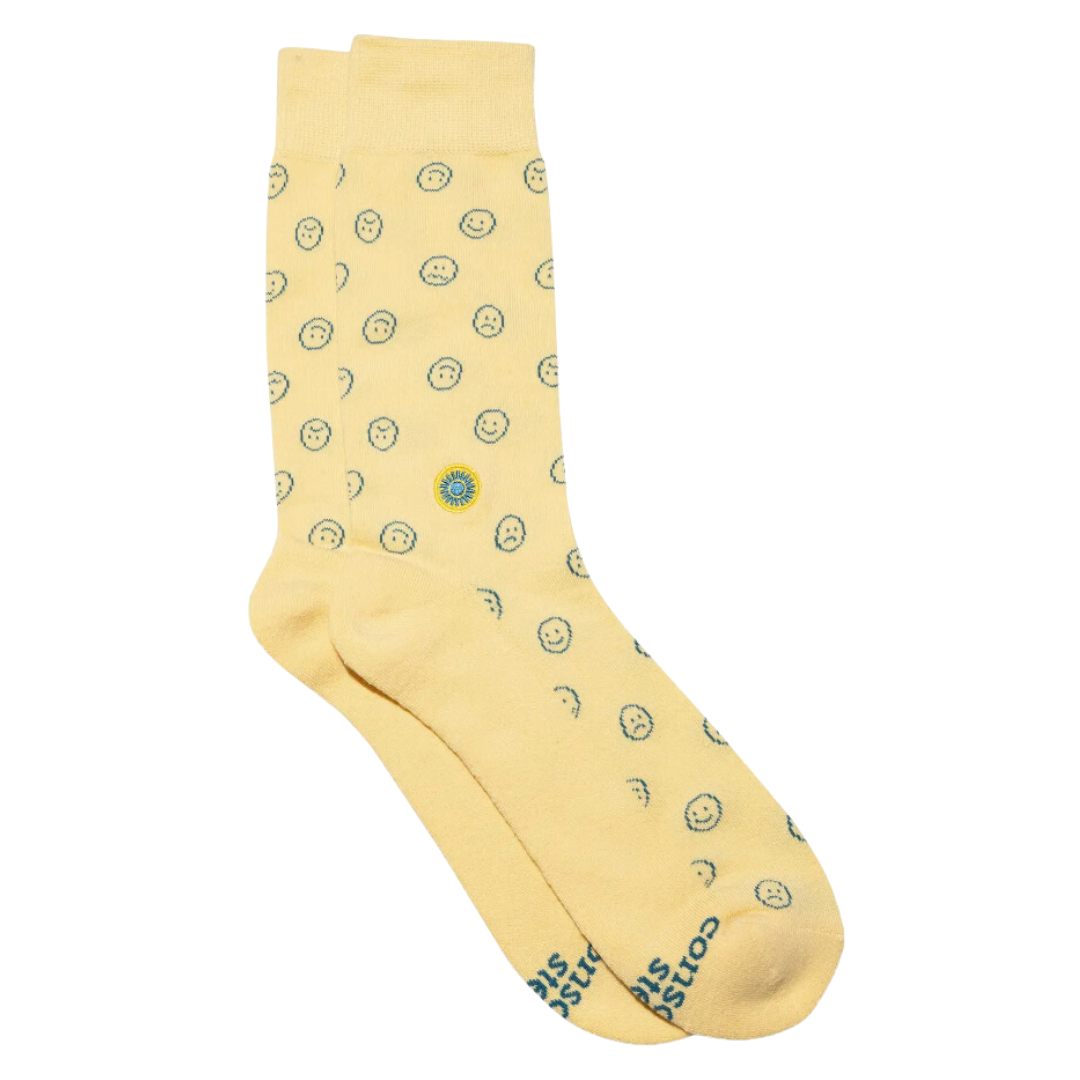 Cheerful yellow socks with a smiley face, uplifting your style and supporting mental health causes by Conscious Step.