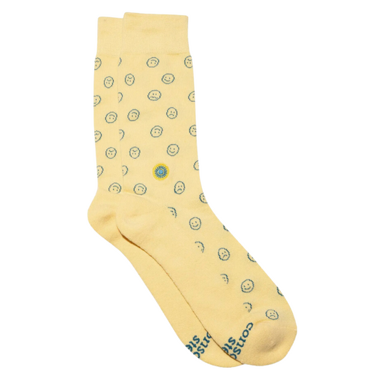Cheerful yellow socks with a smiley face, uplifting your style and supporting mental health causes by Conscious Step.