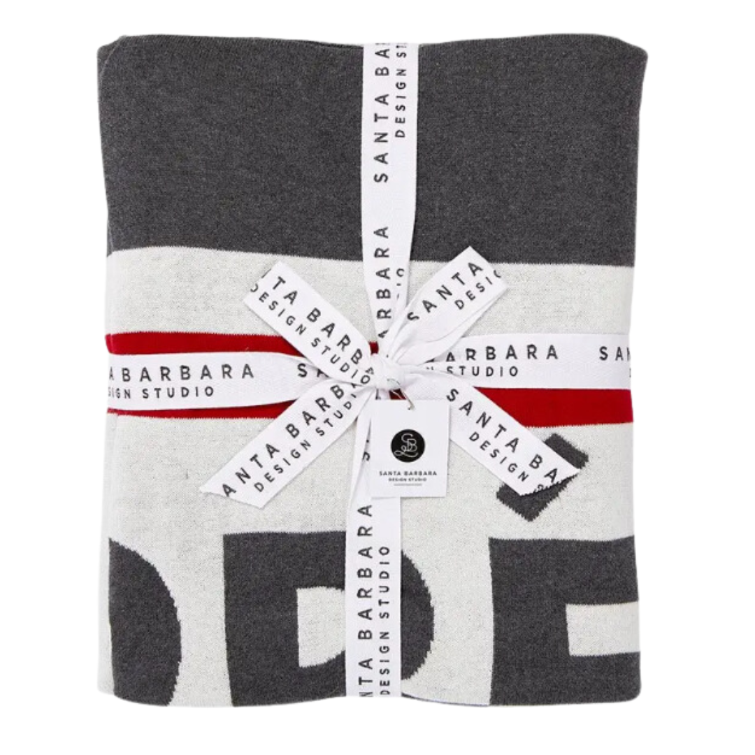 Charcoal 50x60 inch cotton throw blanket with 'Aprés Ski' text in bold red and white, adding a stylish and cozy touch to any room.