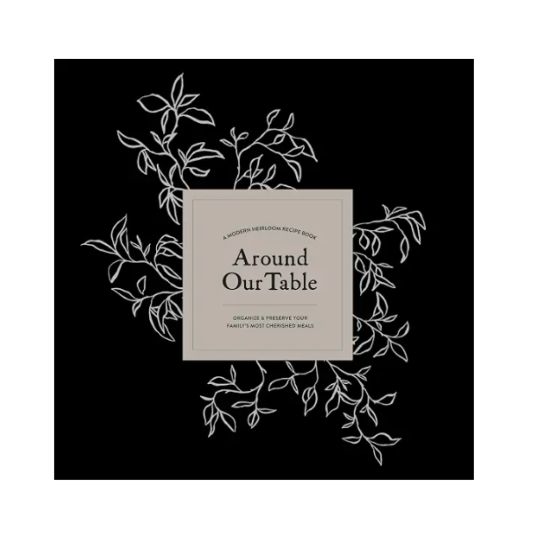 A book cover for 'Around Our Table' by Mary's Most Chosen Meals, featuring a central beige square with black text on a solid black background, framed by delicate white line drawings of leaves and branches.