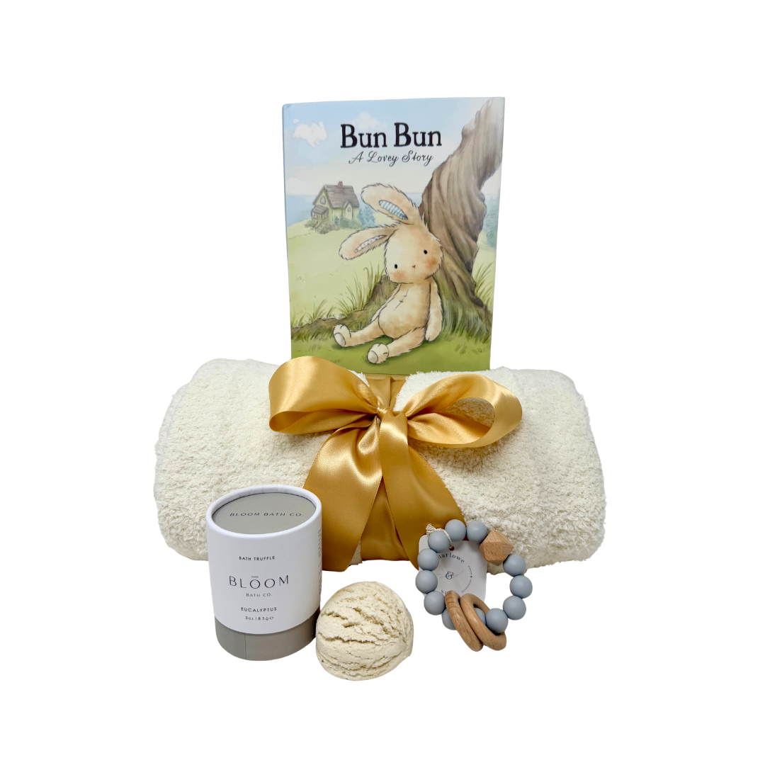 Baby gift set with blanket, book and teething rattle on a white background