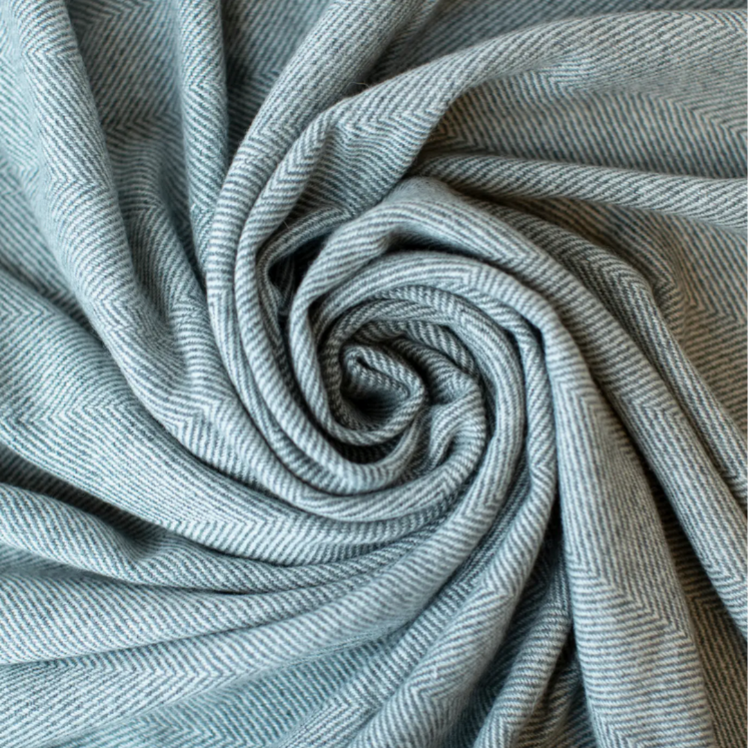 Close-up of textured gray cashmere blanket in a swirl pattern.