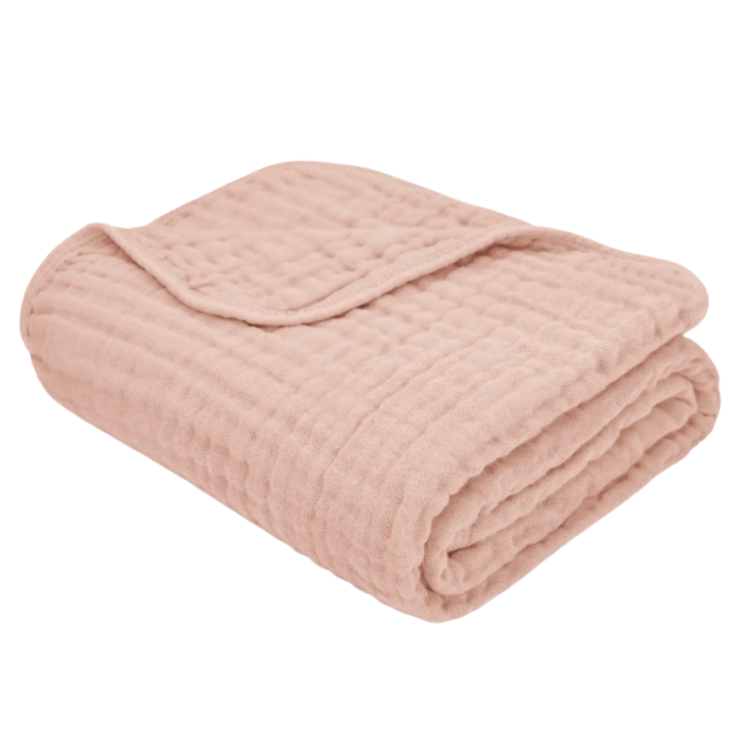 Folded muslin blush pink blanket on a white background.