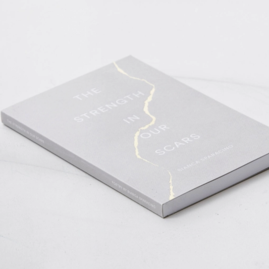 A book titled 'The Strength in Our Scars' by Dr. Sarah M.
