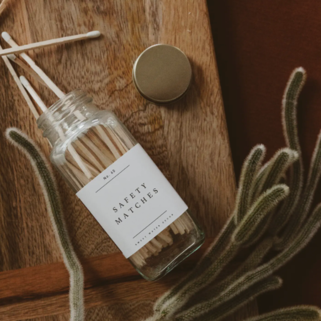 Jar of safety matches with a label on a wooden surface