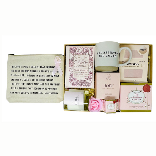 Gift box for breast cancer warriors containing all things pink. Hand selected teas, satin pillow case, "I believe in pink" canvas pouch, self care journal, "Hope" candle and "She believed she could" stoneware mug are all beautifully gift wrapped and ready to ship with your personal gift message.