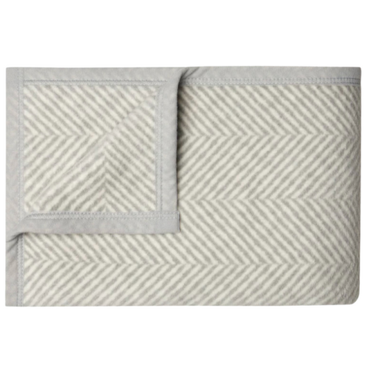 The Herringbone Blanket by Chappywrap in grey and ivory, featuring a timeless plaid design. This 40" x 60" throw is soft, durable, and machine washable, ideal for adding a cozy, stylish touch to any space.