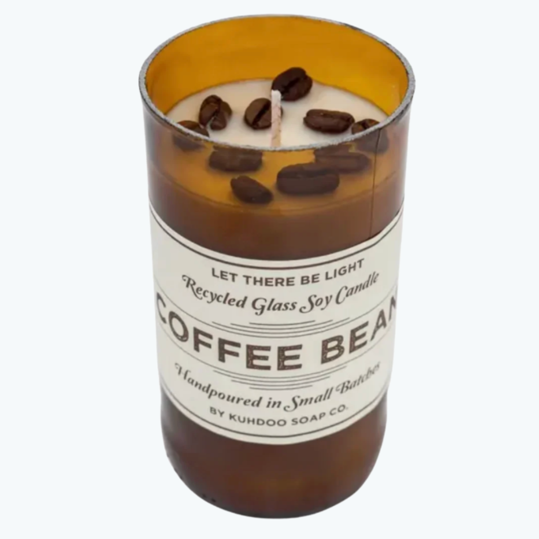 A coffee bean scented soy candle in a recycled glass jar with a white label, featuring whole coffee beans floating in the wax, set against a plain white background.