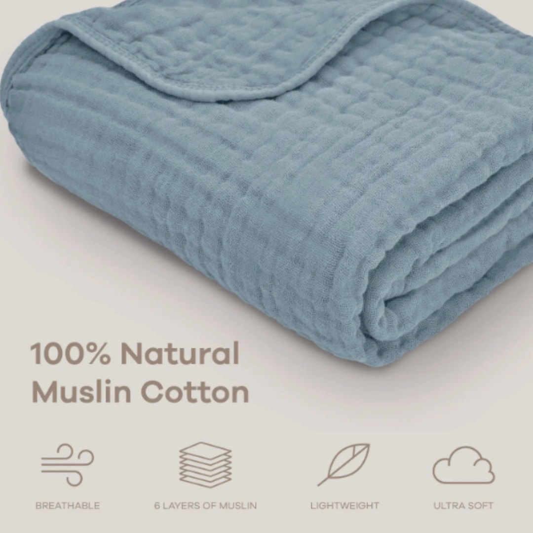 Natural blue muslin cotton blanket folded on a cream background.