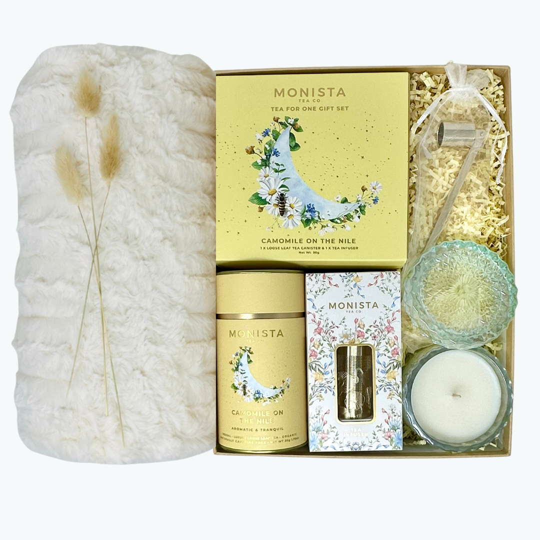 Monista tea gift set with tea set, Aqua de Soi candle, candle snuffer, balnket and other items in a decorative box.
