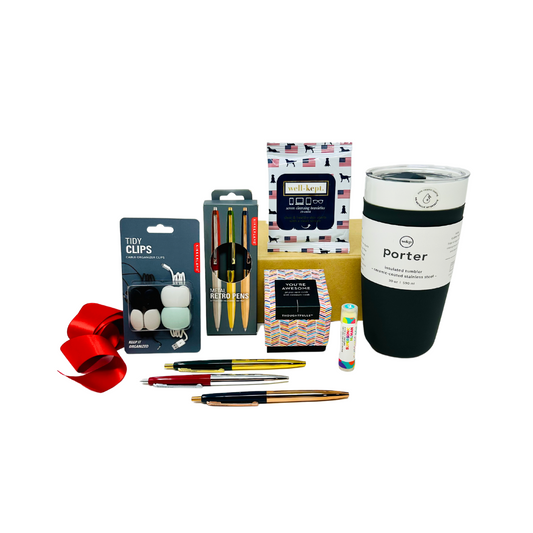 A sophisticated, curated gift box from Me To You Box, named 'Desk Essentials.' It features premium office essentials neatly arranged, including a reusable tumbler, screen cleaner wipes, and high-quality writing instruments and more. Perfect for professionals and anyone looking to elevate their workspace.