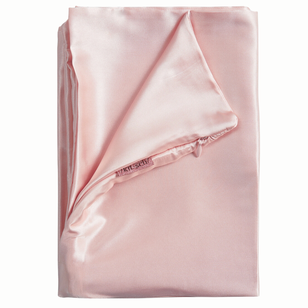 Elegant blush pink satin pillowcase that aids in temperature regulation and moisture retention, perfect for managing night sweats and dry skin during breast cancer treatment. Its easy-care properties make it a practical choice for daily comfort.