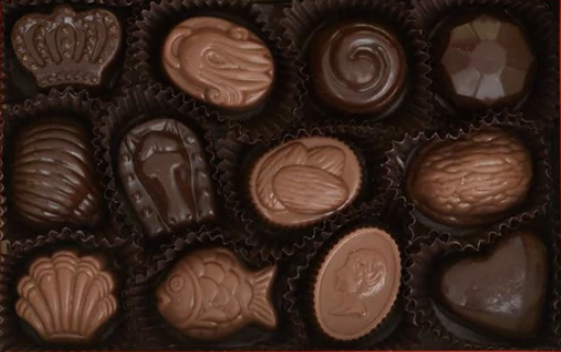 Luxury Louis Sherry gift box with 12 artisan truffles neatly packaged in an open tin.