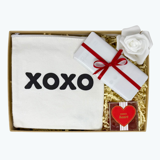 Gift set with a zipper pouch, Sugarfina gummy candies and a chocolate bar in a box.