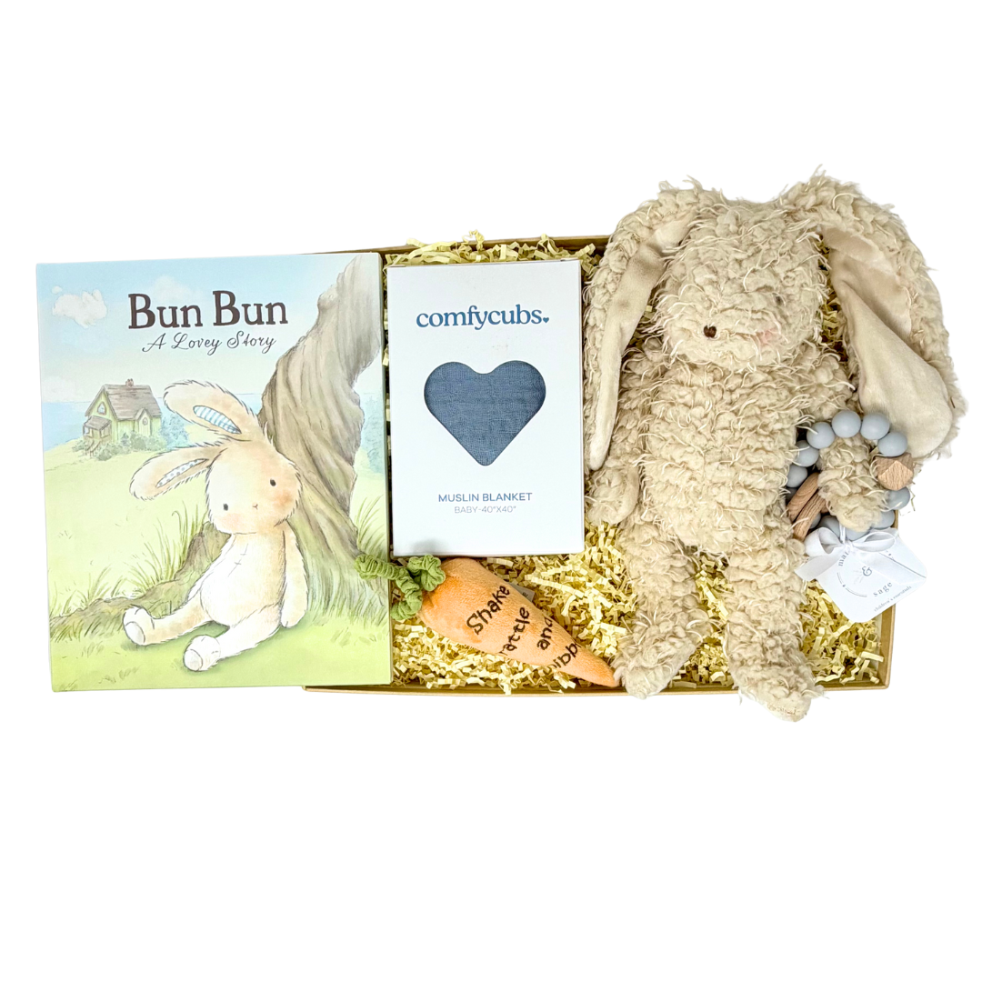 Gift set with plush bunny, plush orange carrot, teether, book, and blanket in a box.
