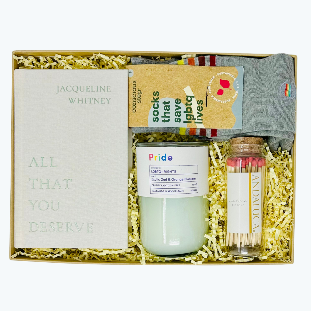 Gift set with a book, candle, matches, and socks in a box.