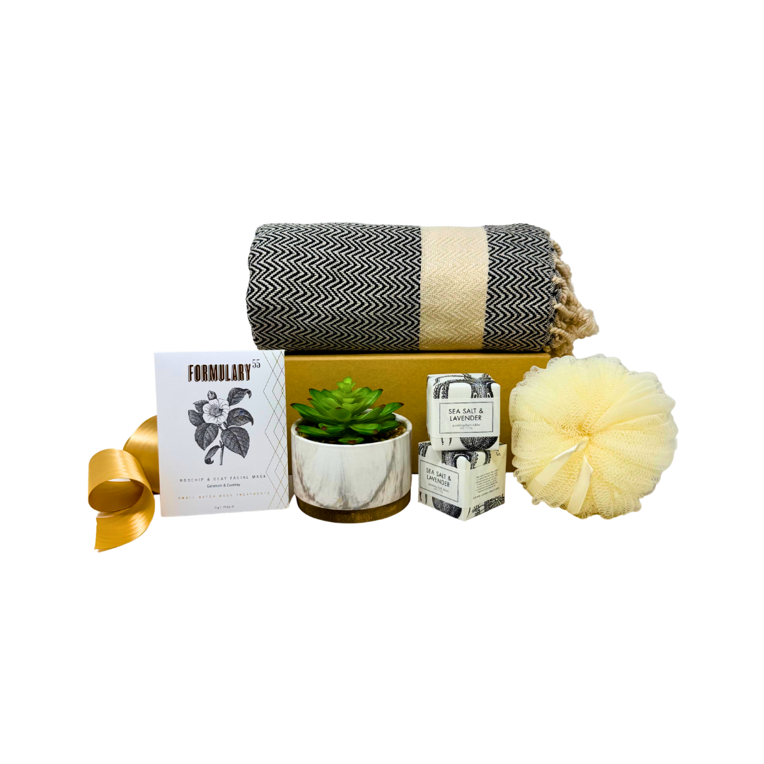 Gift set with blanket, plant, and decorative items on a white background