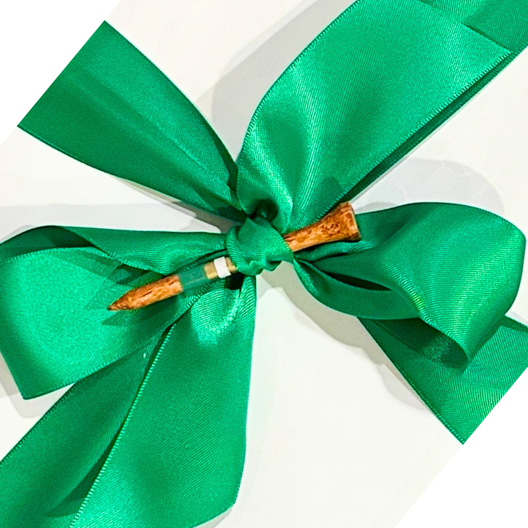Green ribbon bow with a wooden golf tee on a white gift wrapped box.