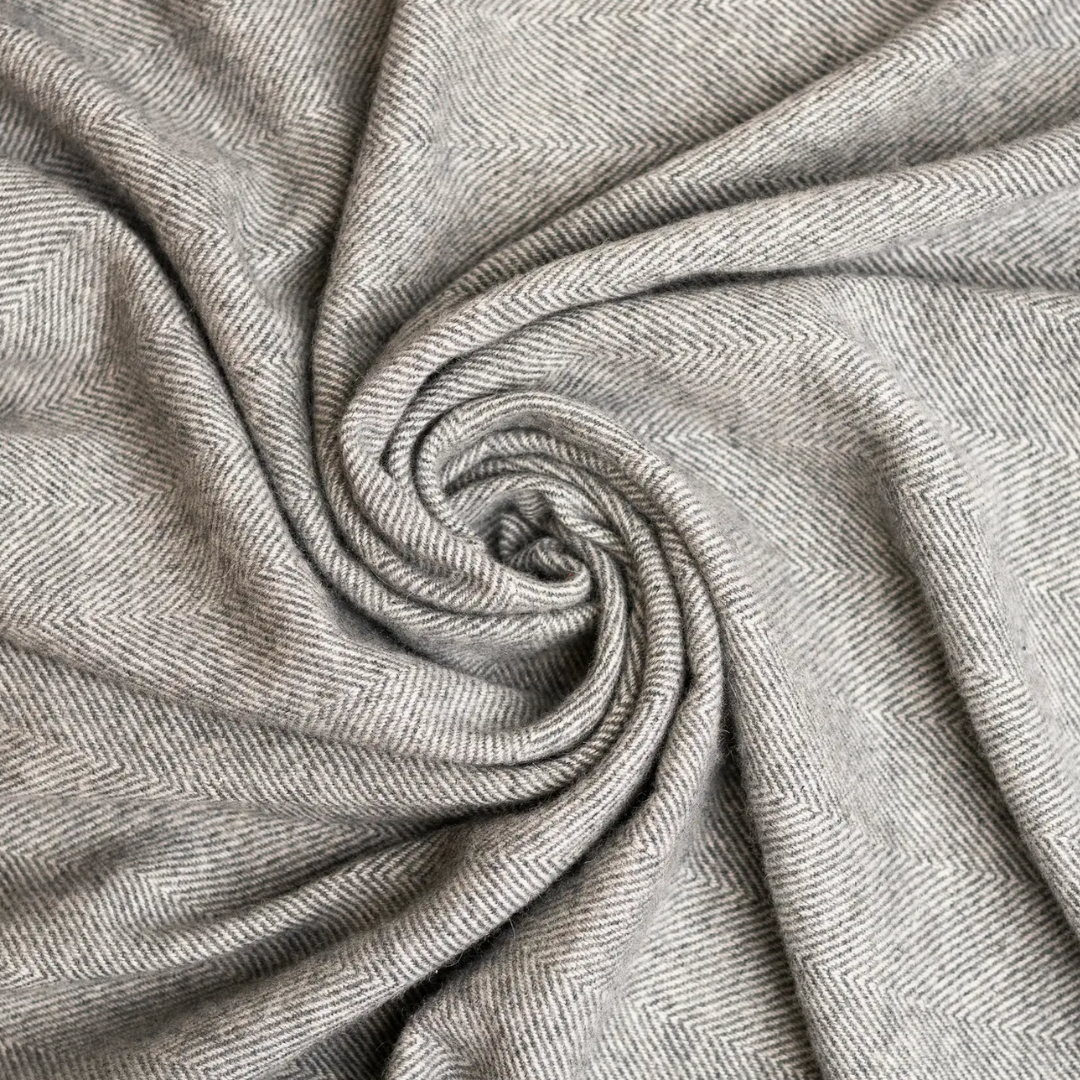 Close-up of gray cashmere fabric with a subtle pattern.