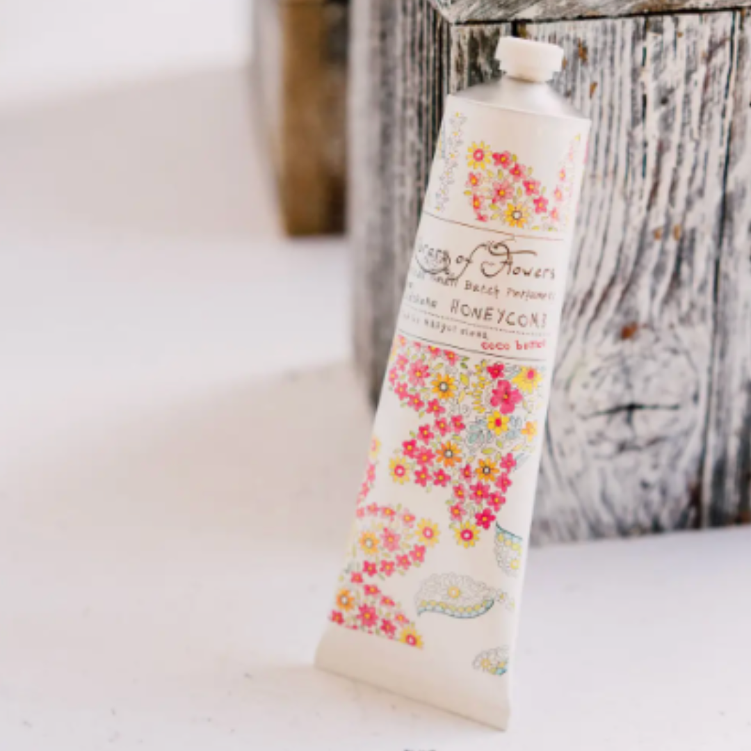 Hand cream tube with floral design on a wooden surface