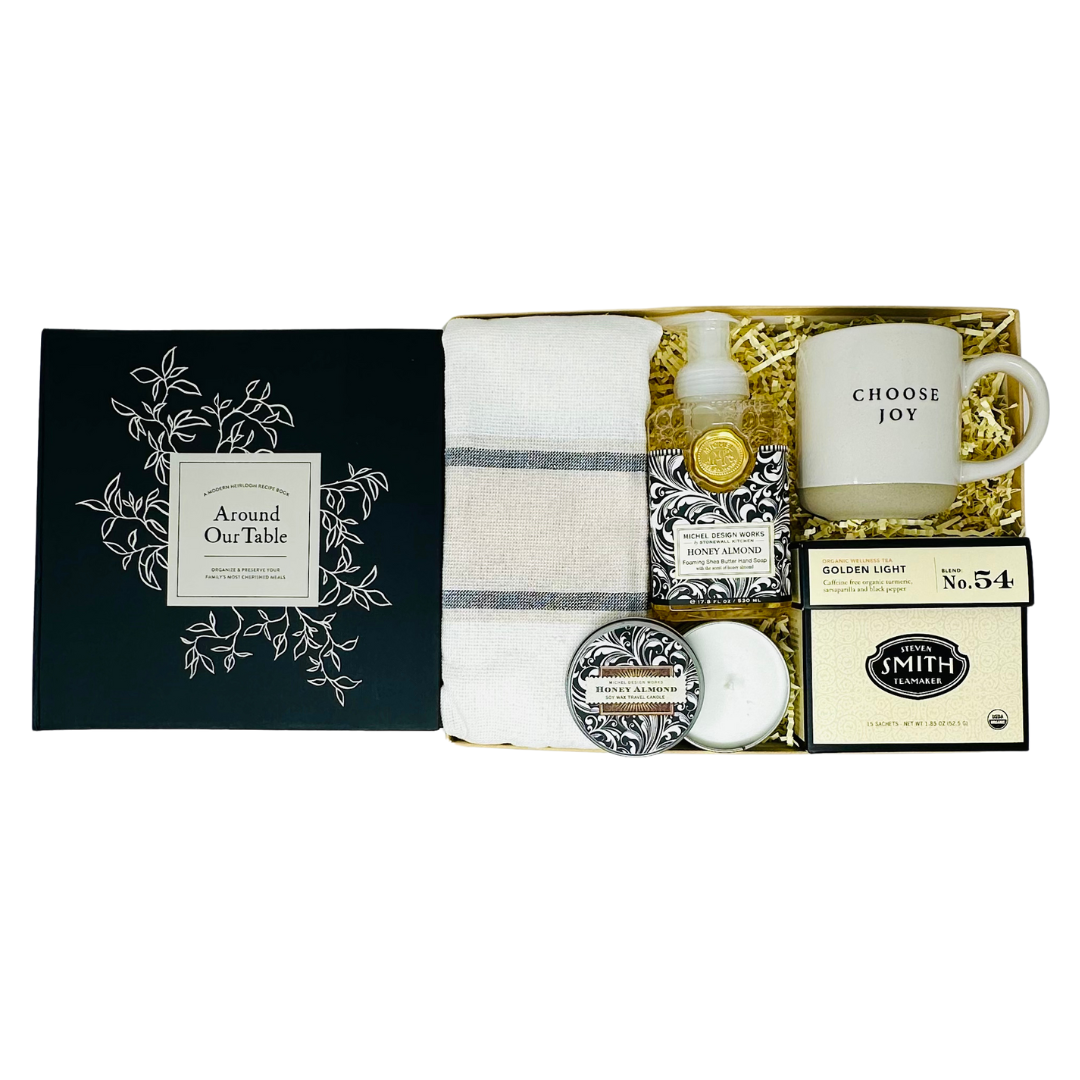 The "Heart Of The Home" gift box by Me To You Box, showcasing a selection of luxurious home essentials like artisanal soaps, cozy throw blankets, and decorative accents, all presented in a sophisticated, personalized gift box.