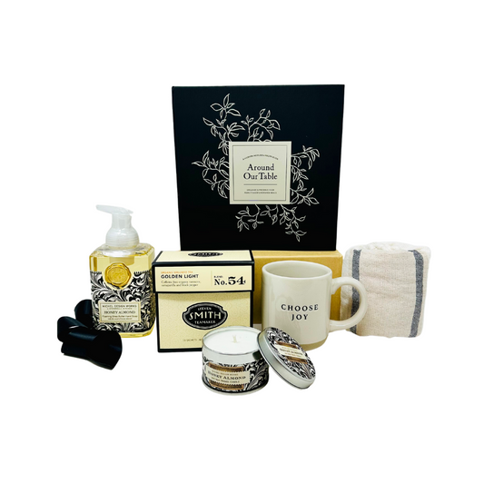 A beautifully arranged "Heart Of The Home" gift box from Me To You Box, featuring an assortment of curated items including candles, home decor, and gourmet treats, all elegantly packaged in a stylish box.