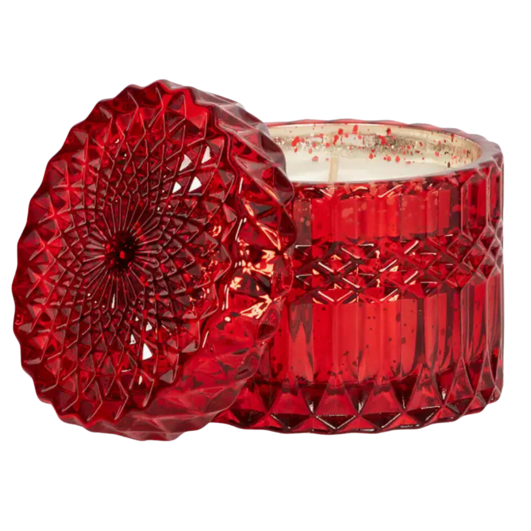 Holiday Spice Glass Soy Wax Candle in a red cut glass container. The candle features a rich, soy wax and a festive red color. It promises a warm, inviting aroma of nutmeg, cinnamon, cardamom, vanilla bean, and mandarin zest. The 8oz candle is designed to burn for approximately 45 hours, providing a long-lasting, cozy fragrance.