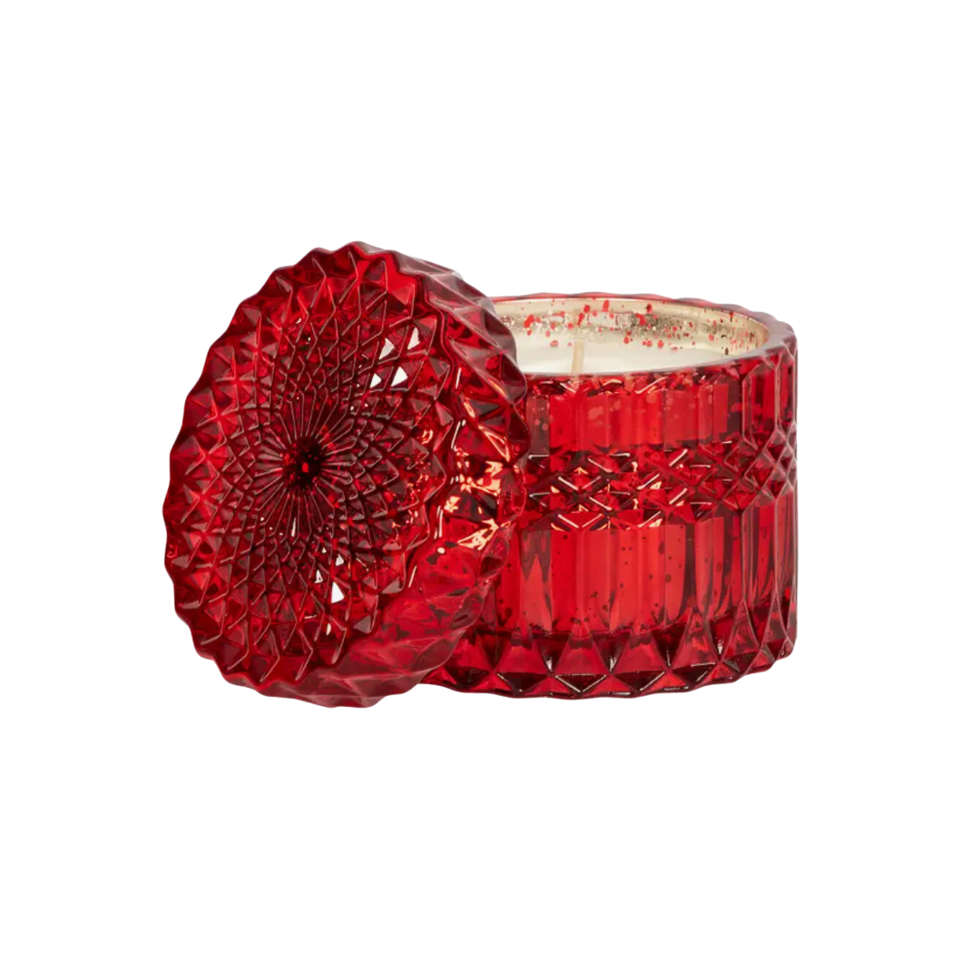 Shimmer Collection by Aqua de Soi, featuring stunning 8-ounce soy candles designed to elevate any space with their luxurious ambiance. Each candle in this collection offers approximately 45 hours of burn time, ensuring long-lasting enjoyment of its captivating fragrance. Red cut glass vessel with holiday spice  scent.