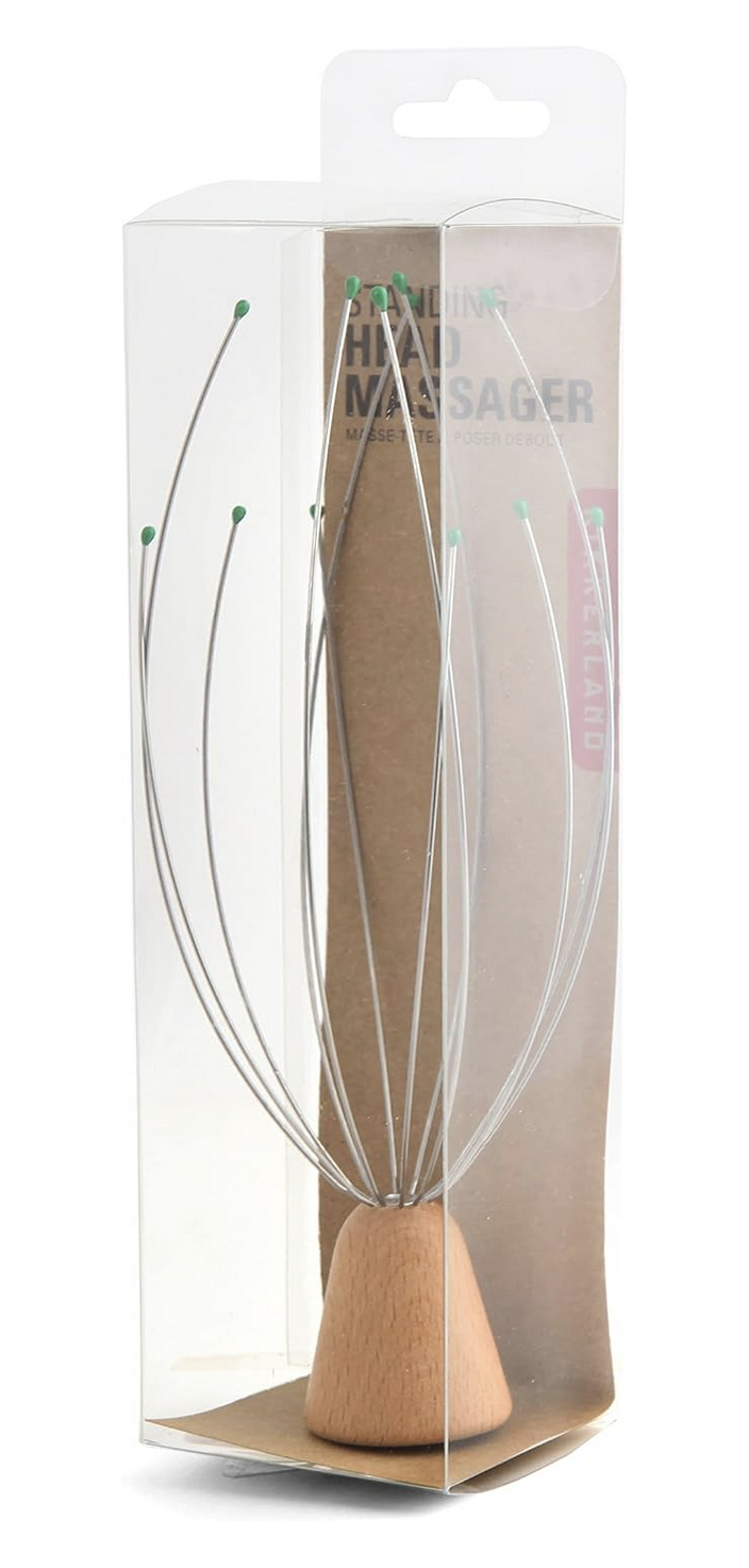 A wire head massager with a light wood cone base, shown inside its clear plastic retail packaging with a brown backing card.